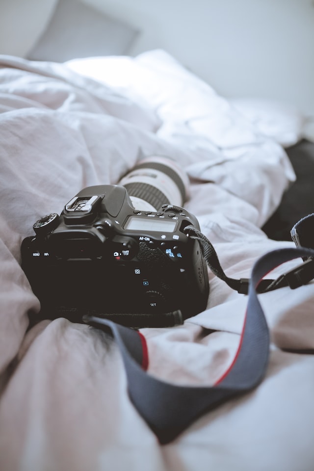 black canon camera on the bed