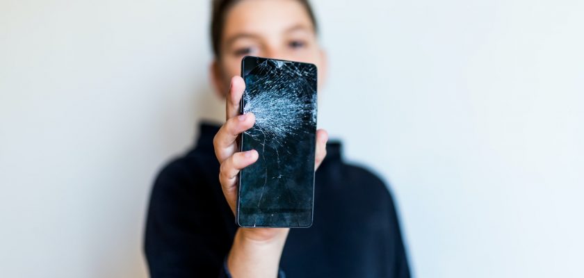 man holding cracked phone