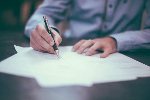 man writing on the documents