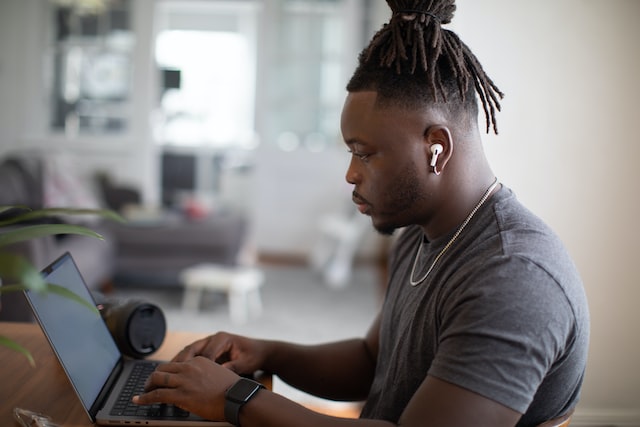 person using laptop with airpods in ears