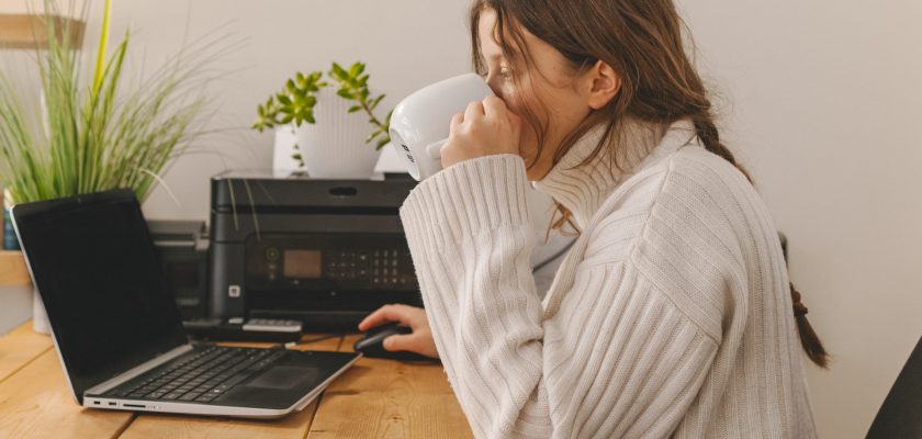 person using laptop with printer connected