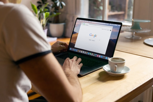 person using macbook with google website opened