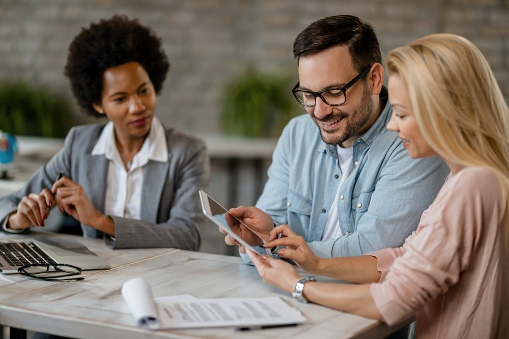 three persons using tablet