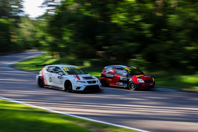 a-couple-of-cars-driving-down-a-curvy-road